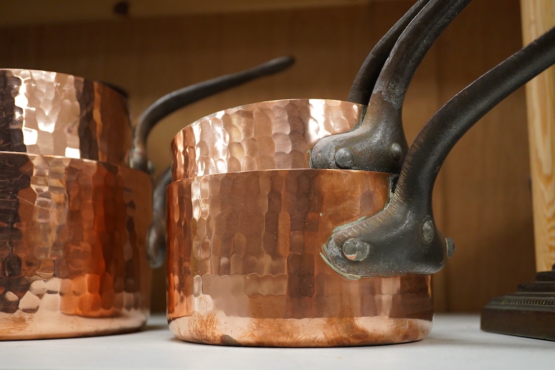 A set of five graduated hammered copper saucepans, largest 37cm in length